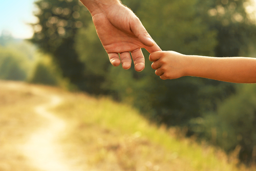 This is an image of a parent holding a child's hand concept of child custody with help of Lincoln County divorce lawyer