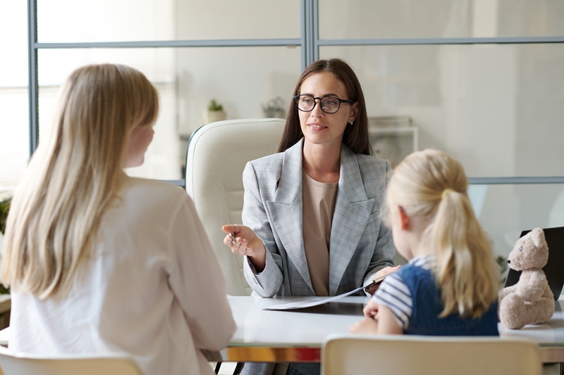 A mother and daughter meeting with a therapist.