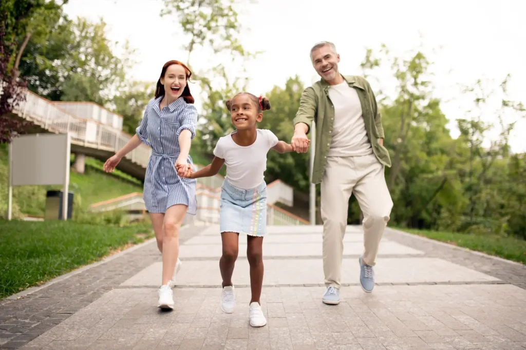 Parents and child walking together outdoors, representing co-parenting, child custody arrangements, and family-focused legal solutions.