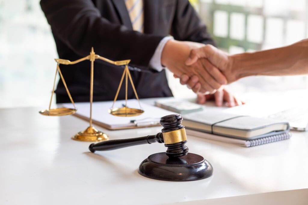A gavel, balanced scales, and documents are on a desk. 