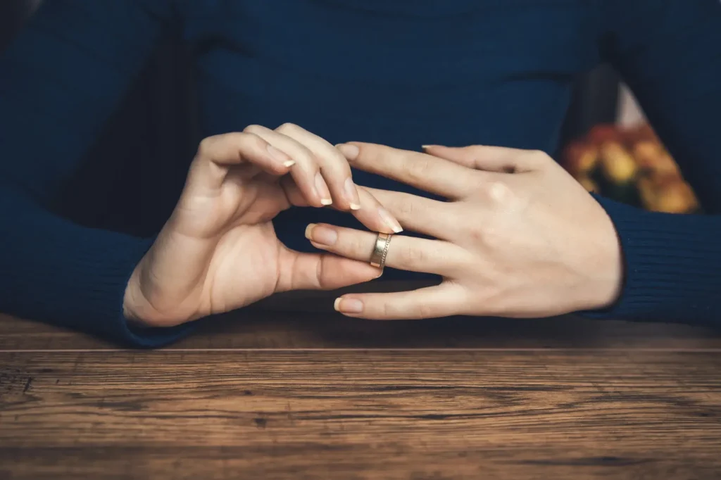 Close-up of a person removing a wedding ring during a divorce or separation discussion in Cabarrus County.