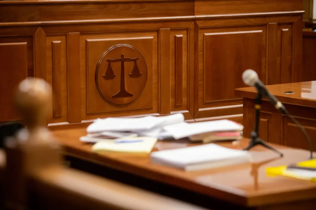 Courtroom with witness stand and scales of justice symbol representing a workers’ compensation appeal hearing or legal proceeding.