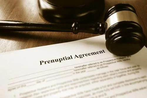 A gavel rests on a wooden desk beside a prenuptial agreement document prepared by Charlotte Family Lawyers.