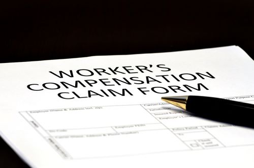A close-up image of a Workers' Compensation Claim Form with a pen placed on top of it, often part of the documentation handled by Charlotte delivery driver Workers' Compensation Attorneys.