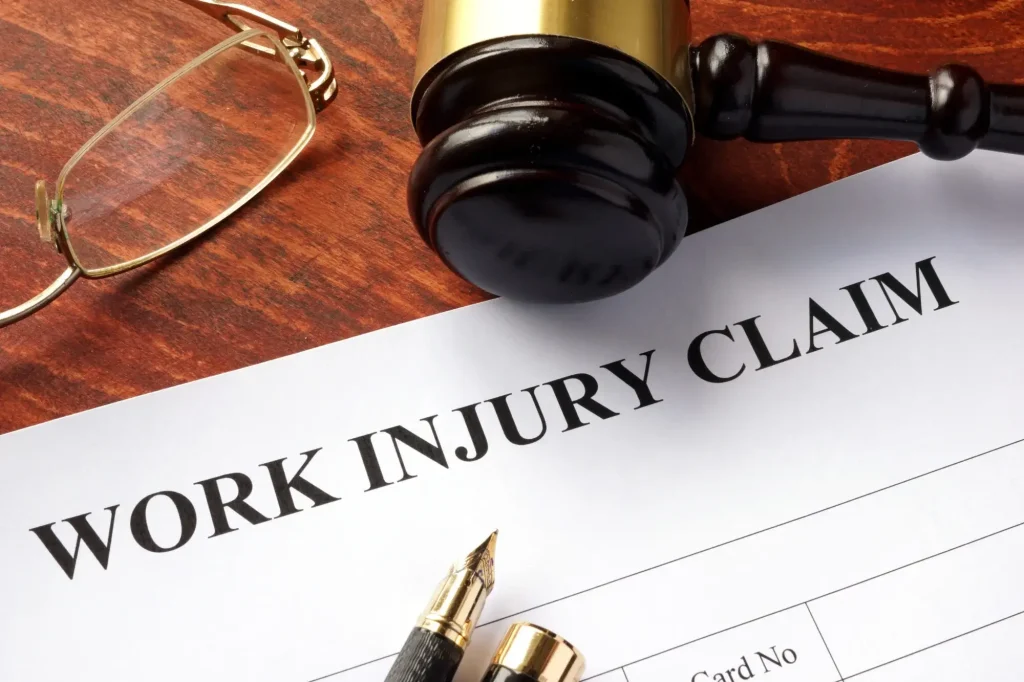 Workers’ compensation claim form with a judge’s gavel and legal documents representing settlement negotiations and claim disputes.