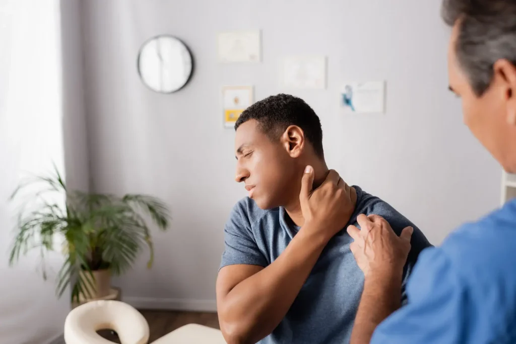 Injured worker discussing shoulder pain and medical treatment with a healthcare provider after a workplace injury.