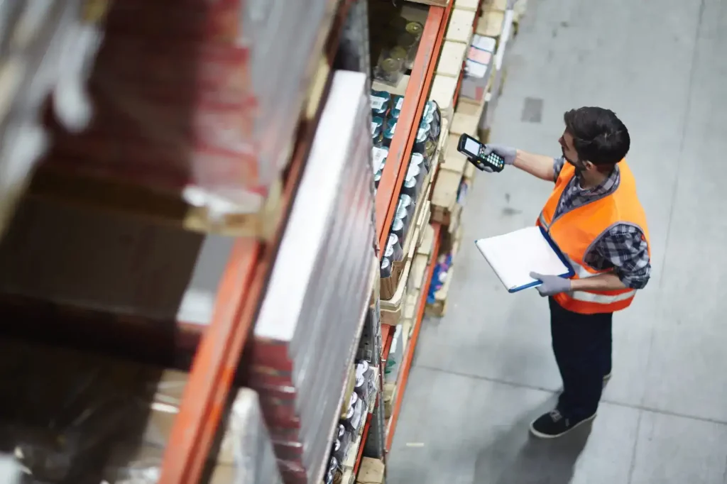 Warehouse employee conducting inventory tasks, illustrating occupations where repetitive stress and workplace injuries can occur.
