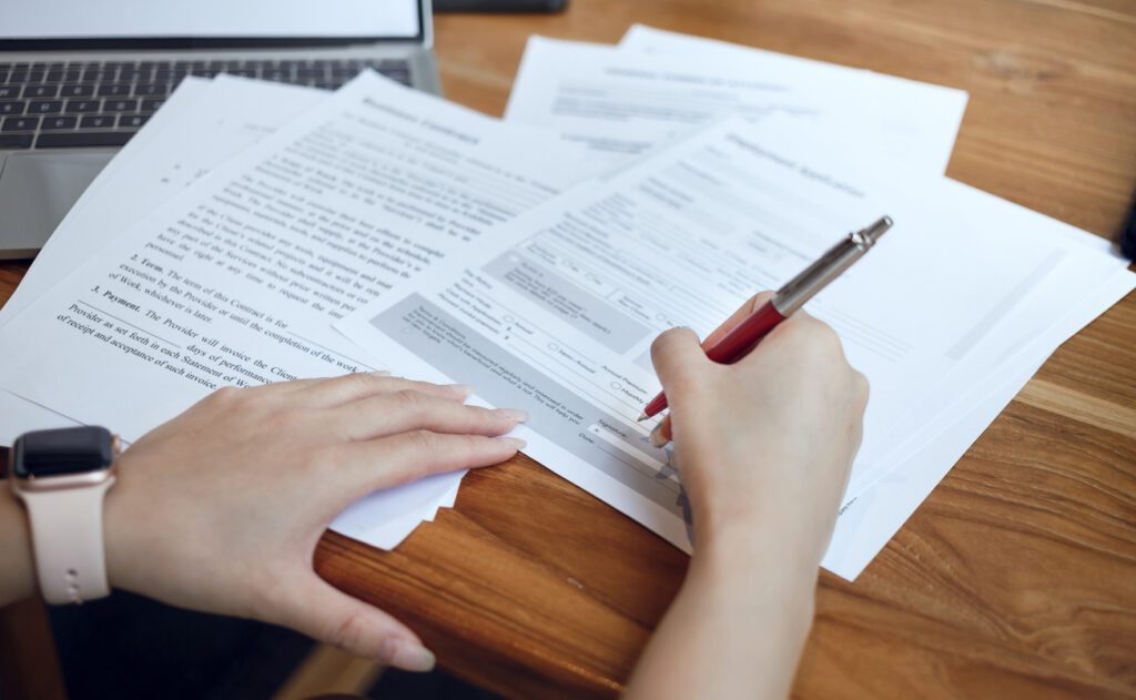 Person organizing medical records, claim forms, and legal paperwork before a first workers’ compensation attorney consultation.