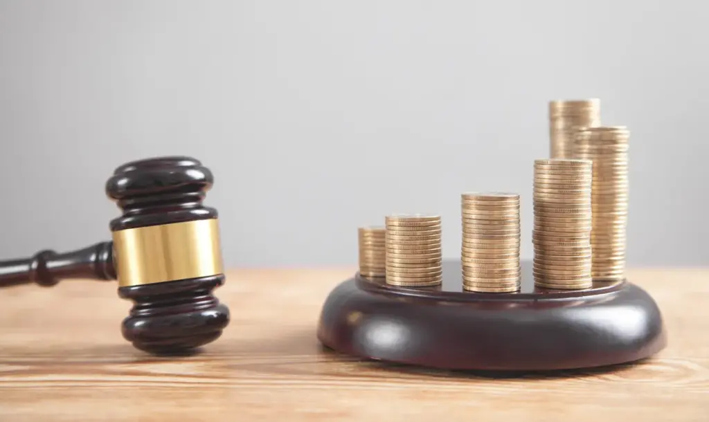 Stacked coins and a gavel representing the financial costs of divorce litigation compared to mediation.