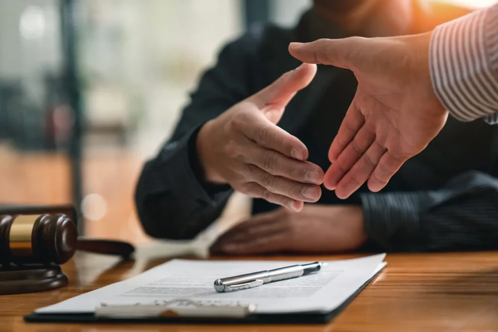 Handshake between attorney and client during a workers’ compensation consultation regarding a workplace injury claim.