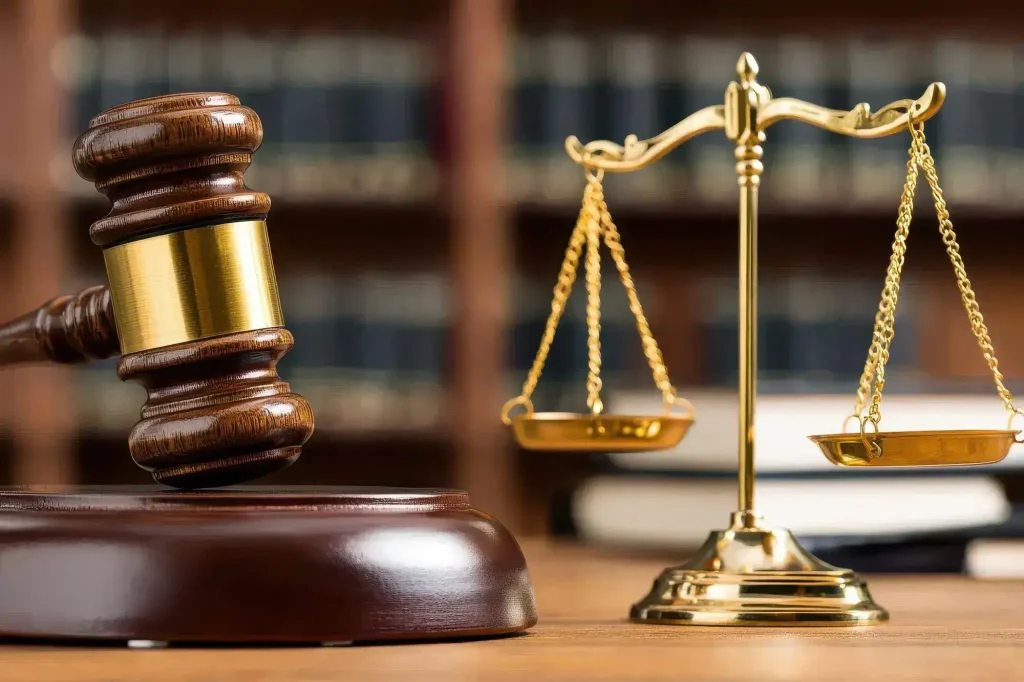 Workers’ compensation attorney reviewing legal documents with scales of justice on a desk during a workplace injury case consultation.