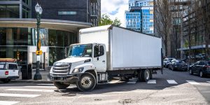 Delivery box truck turning on downtown street, when involved in work vehicle accident meet with Charlotte Workers Comp Attorney for Truck Drivers.