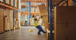 Man falling from stack of boxes falling on him while working in warehouse. Consult with our lawyers for Workers Comp Claim Charlotte