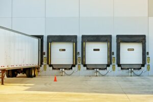Semi Truck Trailer Warehouse Loading / Unloading. Large Modern American Warehouse Building. Shipping and Cargo 