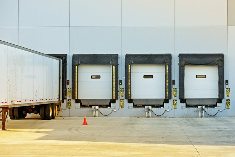 Semi Truck Trailer Warehouse Loading / Unloading. Large Modern American Warehouse Building. Shipping and Cargo