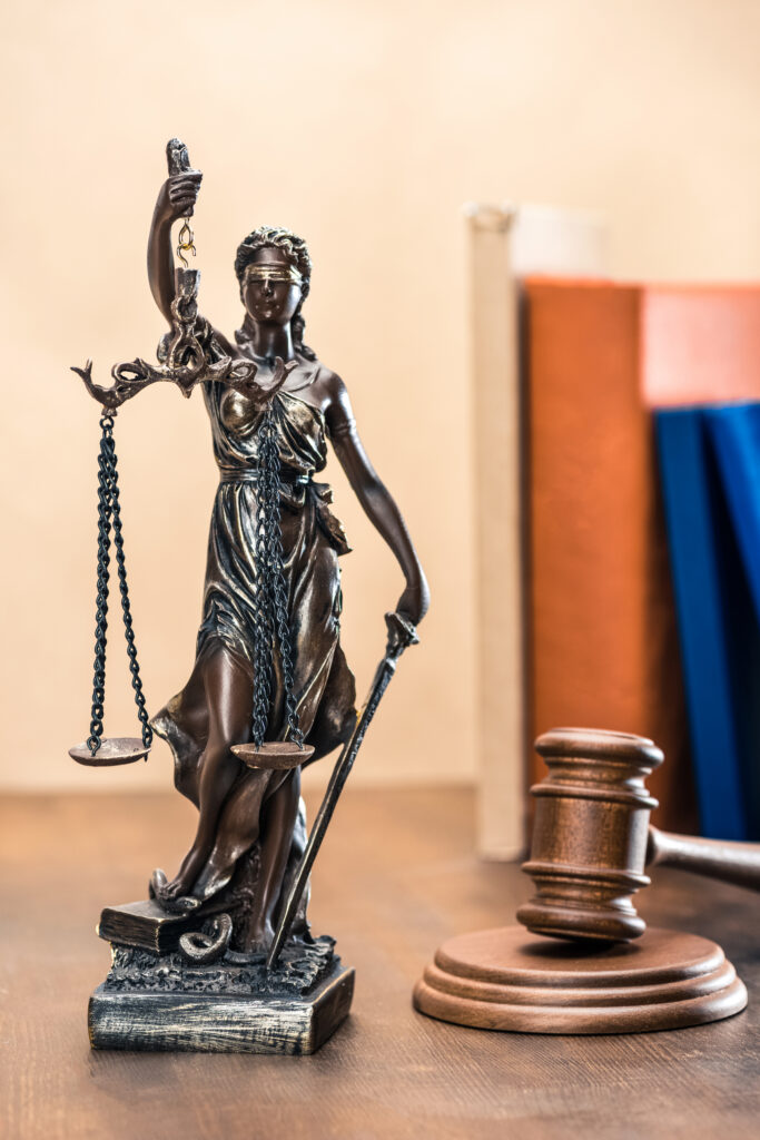 Lady Justice statue and gavel representing legal guidance for injured workers pursuing workers’ compensation benefits in North Carolina.