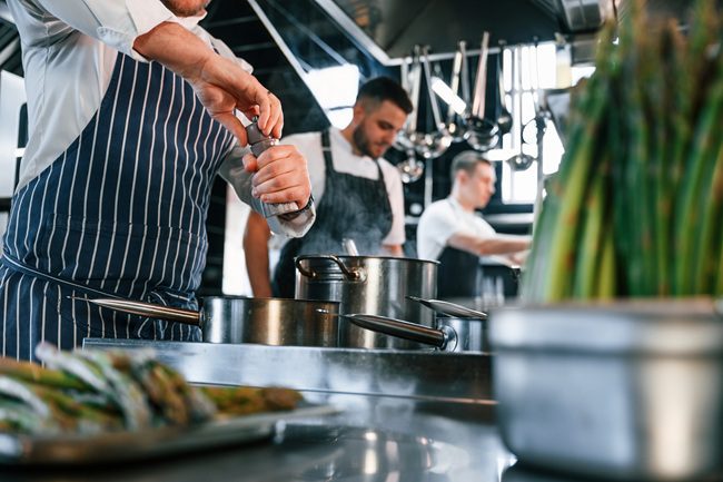 Food service workers in the kitchen. Injuries can happen that require a workers' compensation lawyer for restaurant workers.
