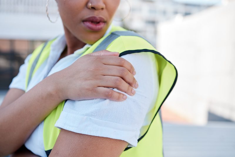 Woman, engineer and hands with shoulder pain outdoor from injury, accident and muscle tension on ro.