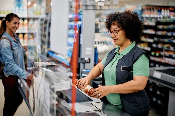 retail cashier scanning groceries. This can result in repetitive strain injuries for retail workers.